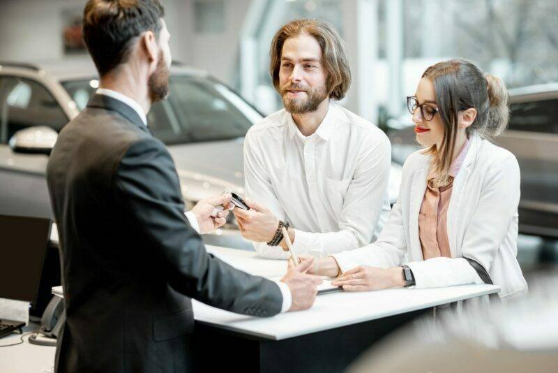 business-couple-at-the-stand-with-salesperson-in-t-2021-12-09-02-10-05-utc-1-1-scaled-e1660134679417.jpg