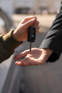 Remise d’une clé de voiture entre deux personnes.