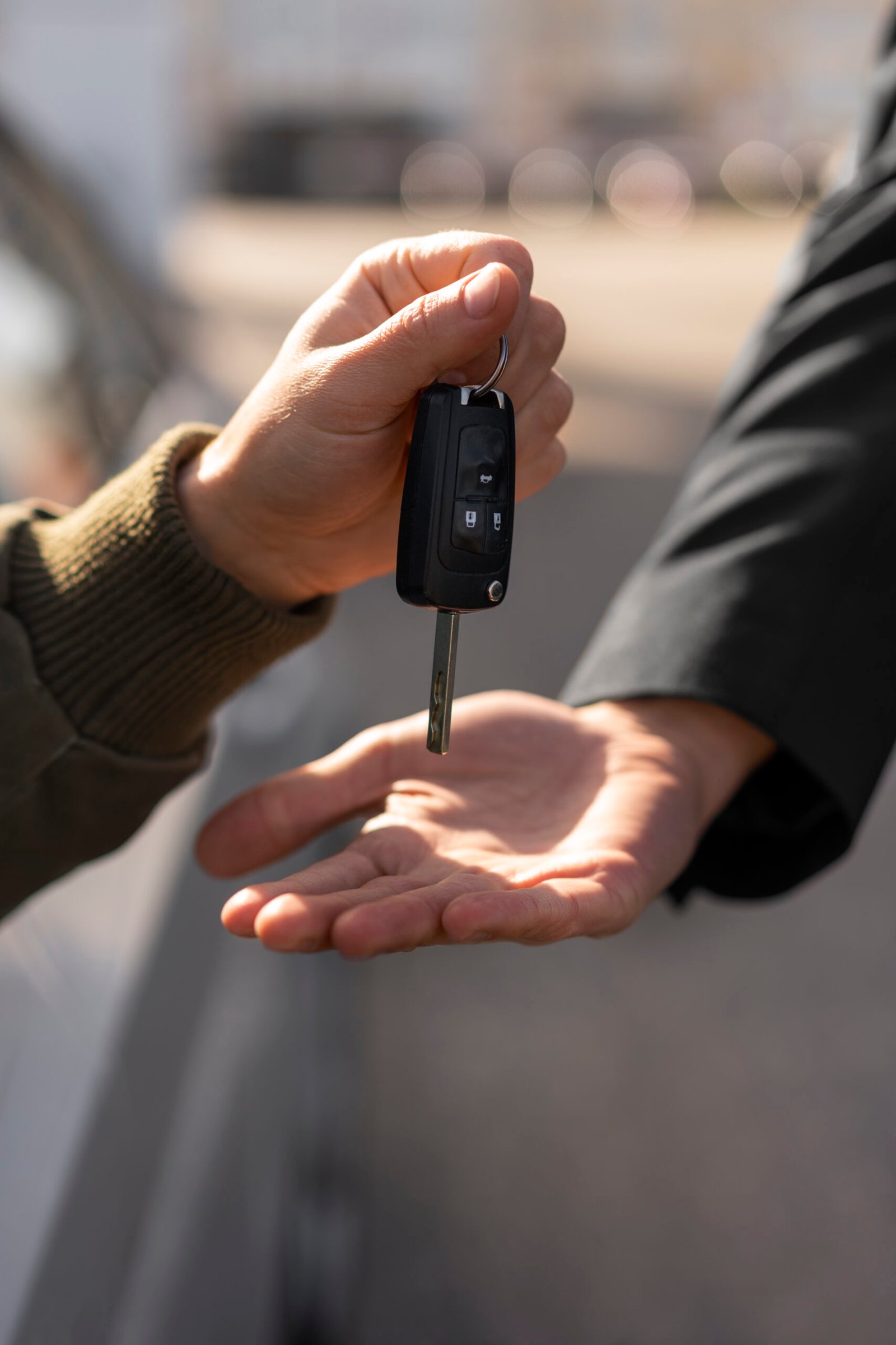 Remise d’une clé de voiture entre deux personnes.