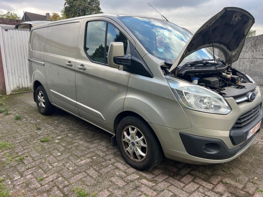 Ford Transit de 2018 racheté à Genappe, vu de trois quarts avant avec le capot ouvert.